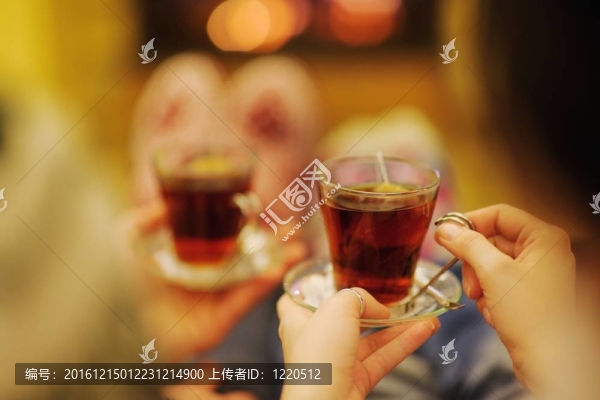 快樂的年輕情侶坐在家里壁爐前的沙發(fā)上