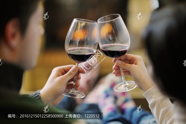 快樂的年輕情侶坐在家里壁爐前的沙發(fā)上