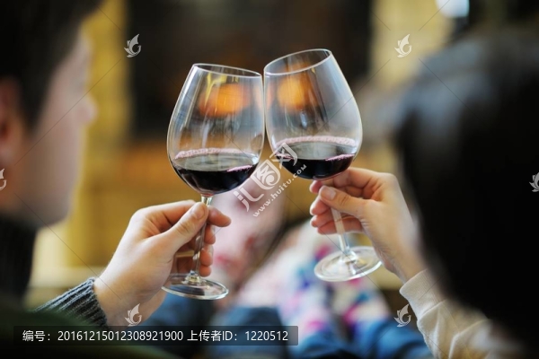 快樂的年輕情侶坐在家里壁爐前的沙發(fā)上