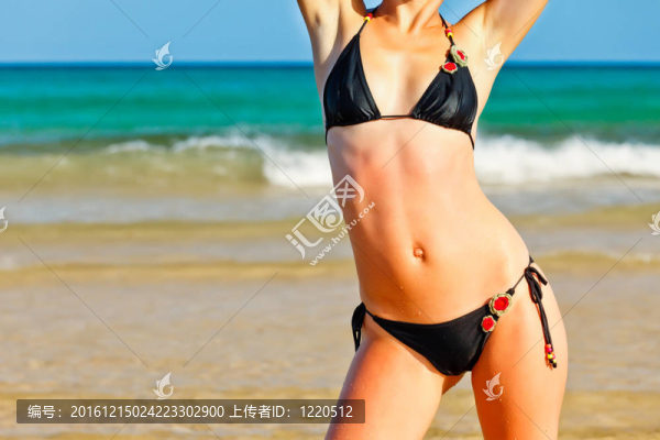 年輕女子在沙灘上比基尼