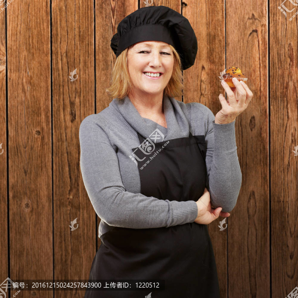 中年女人抱著對做木墻自制的松餅的肖像