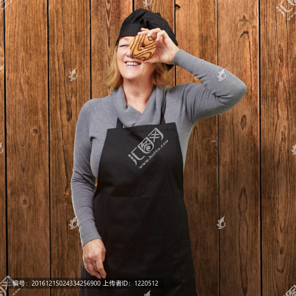 中年婦女看著廚師在木墻上的甜甜圈