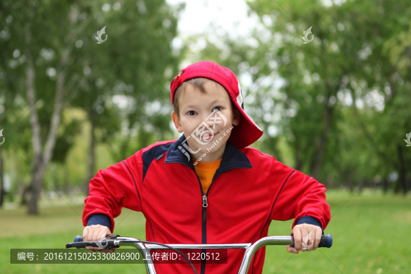男孩在公園綠地中的自行車