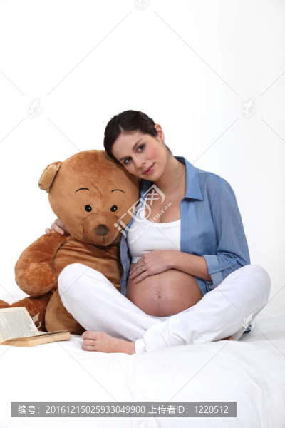 懷孕的女人抱著一只泰迪熊