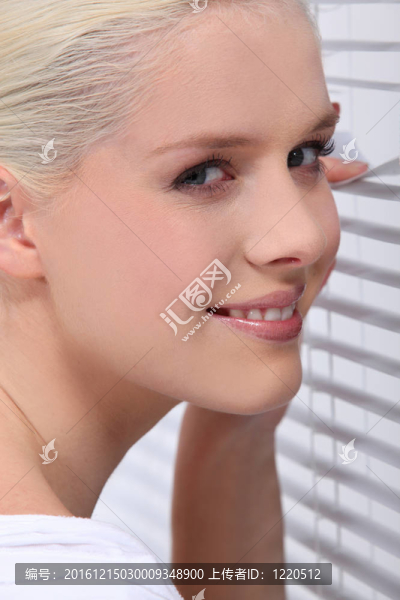 金發(fā)女人透過(guò)百葉窗偷看