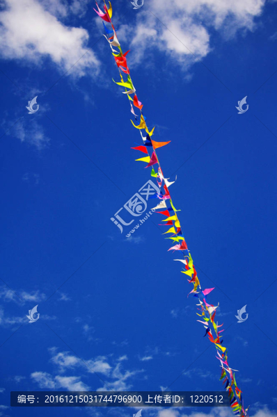 在藍(lán)色天空背景下，有蓬松的白云的彩色旗幟