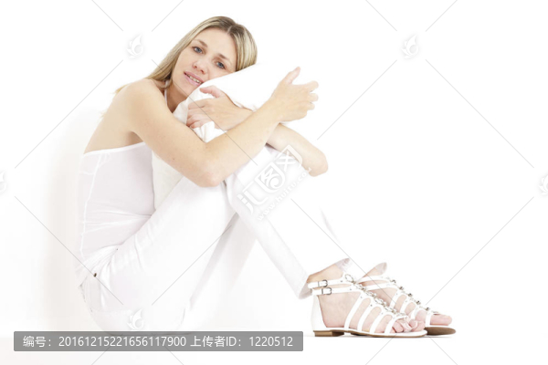 坐著的女人穿著白色的衣服和涼鞋