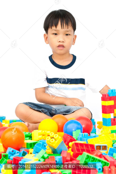 在白色背景上玩玩具的小男孩