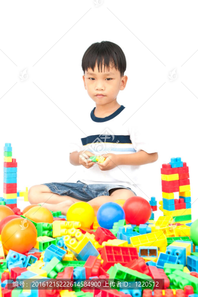 在白色背景上玩玩具的小男孩
