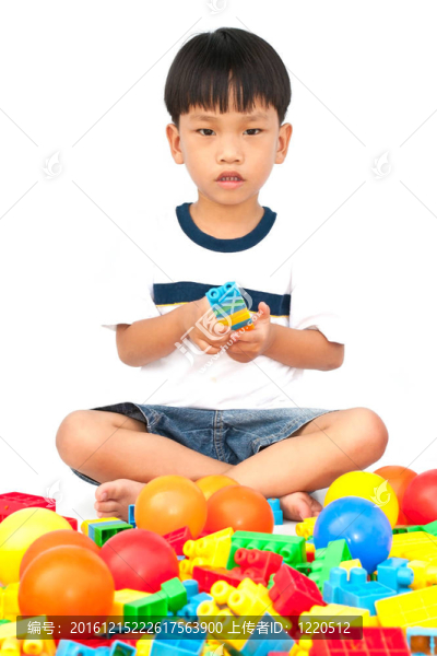 在白色背景上玩玩具的小男孩