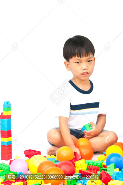 在白色背景上玩玩具的小男孩