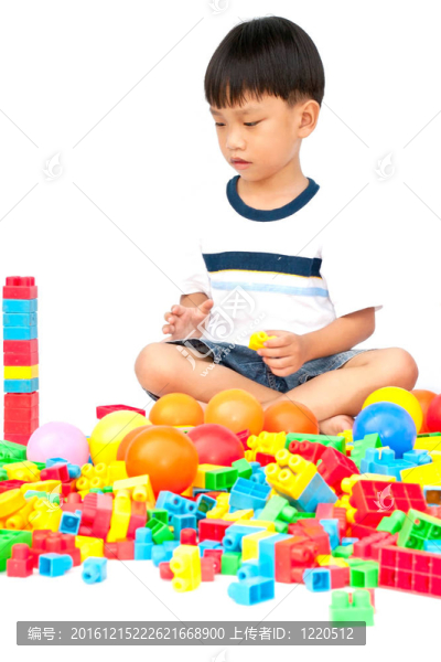 在白色背景上玩玩具的小男孩