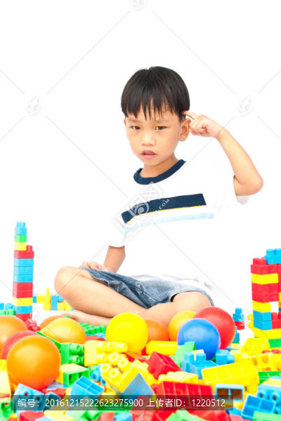 在白色背景上玩玩具的小男孩
