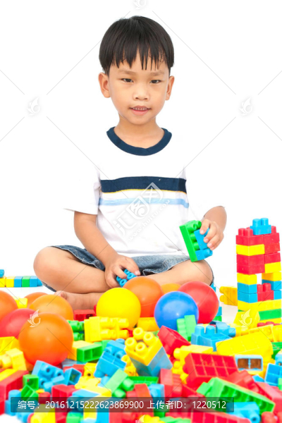 在白色背景上玩玩具的小男孩