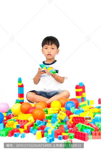 在白色背景上玩玩具的小男孩