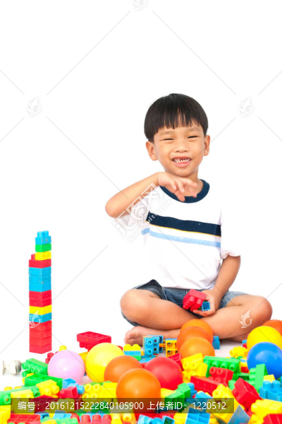 在白色背景上玩玩具的小男孩