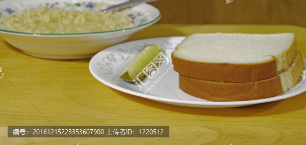 一個盆栽的肉三明治，在一個盤子里用一個勺子在一個碗的碗在背景的背景下，在一個漂亮的木桌使用淺景深和選