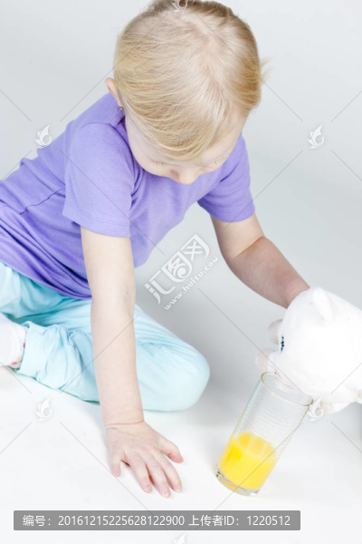 小女孩喝了一杯橙汁和一個(gè)玩具
