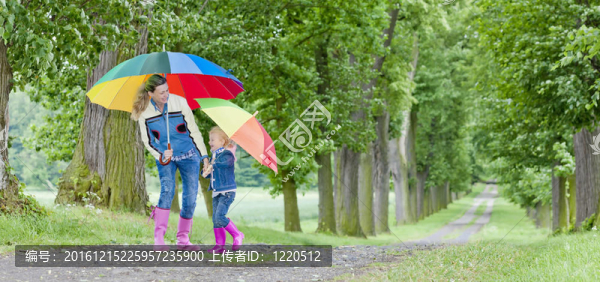 母親和女兒在春天的小巷里帶著雨傘
