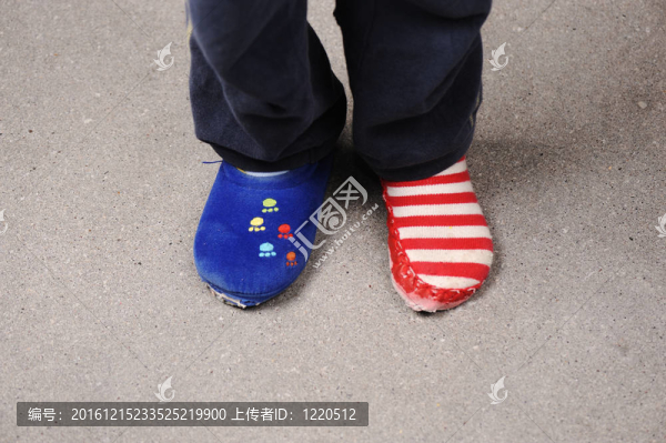 兩個不同的襪子在小男孩的腳上