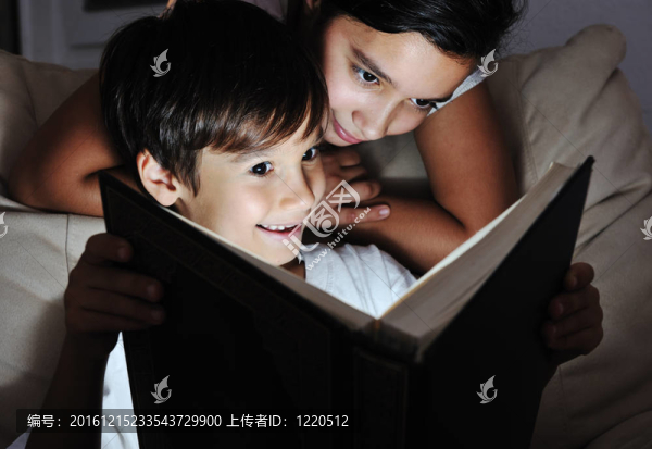 男孩和女孩晚上讀輕書；兒童概念
