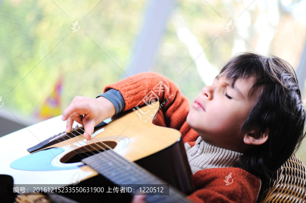 在家玩吉他的小男孩