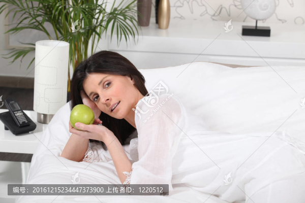 女人躺在床上抱著蘋(píng)果