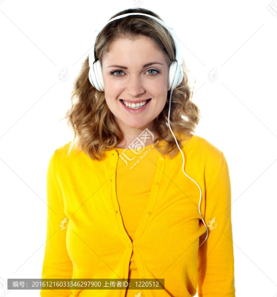微笑的年輕女人在耳機(jī)里聽(tīng)音樂(lè)