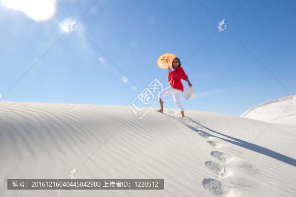 美女在夏日的沙丘上行走