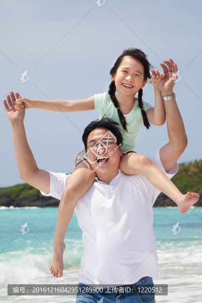 亞裔父親與小女孩在海灘上奔跑