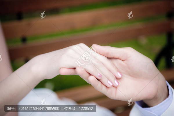 新郎把結(jié)婚戒指戴在新娘的手指上