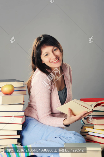 可愛的女孩用一大堆書學(xué)習(xí)