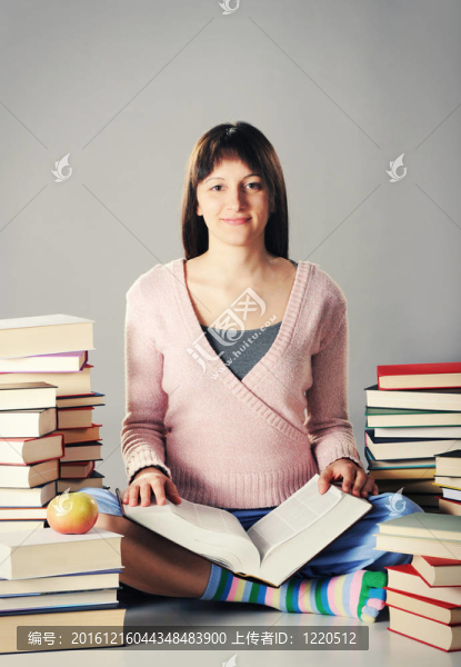 可愛的女孩用一大堆書學習