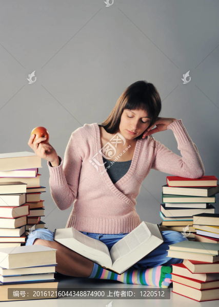 可愛的女孩用一大堆書學(xué)習(xí)