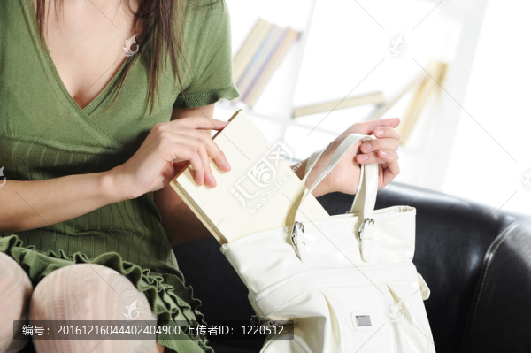 漂亮的年輕女人在書包里拿著一本書