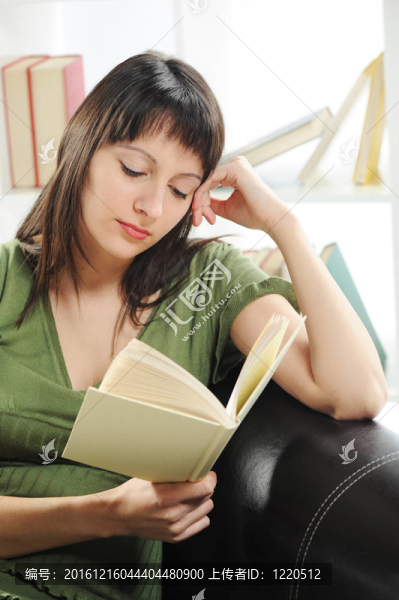 一本書的年輕女人女人肖像；書架上的背景