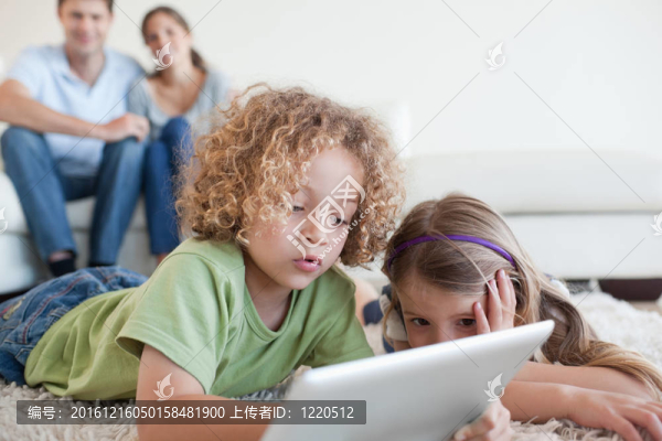 年幼的孩子在快樂的父母使用平板電腦