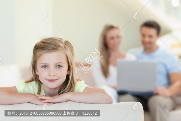 微笑的女孩和父母在她身后