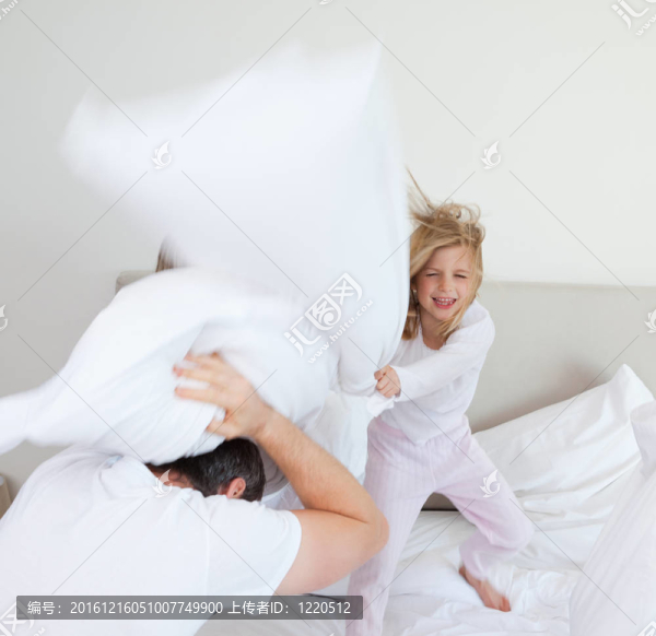 女孩用枕頭打她的父親