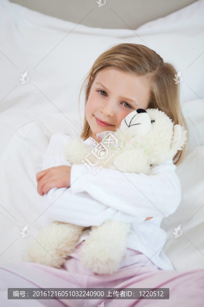 女孩抱著她床上的泰迪熊