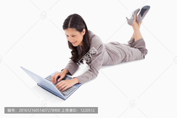說謊的女人在她的筆記本上工作