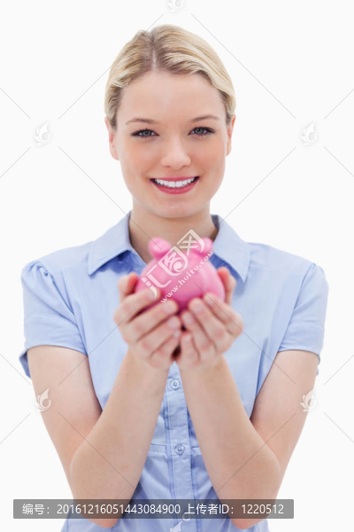 抱著小豬存錢罐的女人