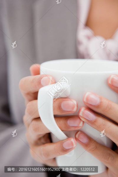 由女性手中舉行的杯子
