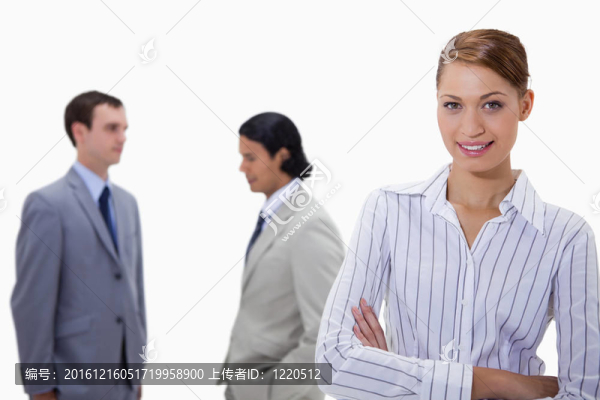 抱著雙臂，在她身后的同事在白色背景的商人