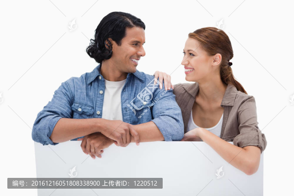 依偎在空白墻上的微笑情侶