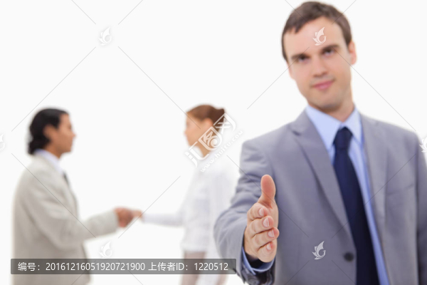商人在背后擺著一副與白人握手的同事的手