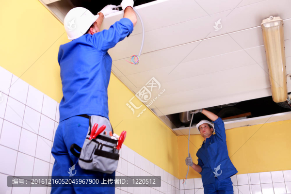 兩個電工檢查天花板面板