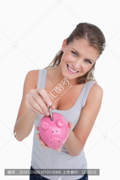 一個微笑的女人在存錢罐里放鈔票的肖像