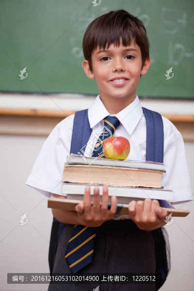 一個小學(xué)生拿著書和蘋果的肖像