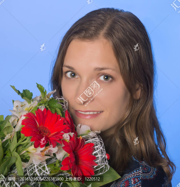 在藍色背景上有花的年輕快樂的女人